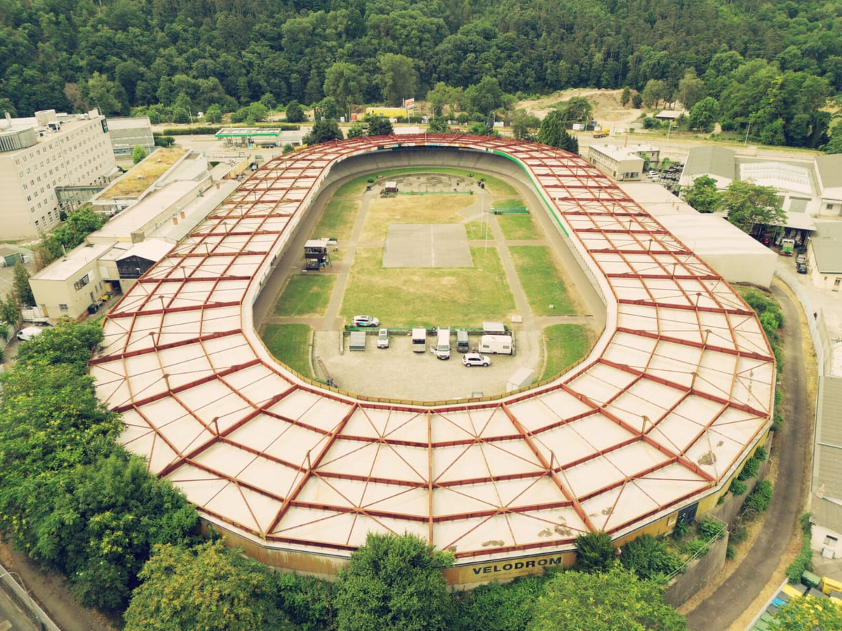 Aktuální podoba velodromu z roku 2023. Fotografie z netradiční severní strany se zalesněnými stráněmi Červeného kopce. 